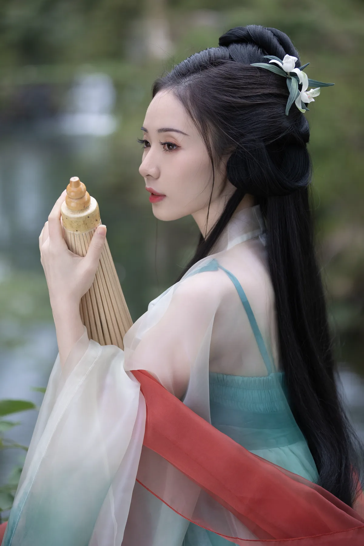 临水场景中手持竹简的青绿色汉服人物肖像